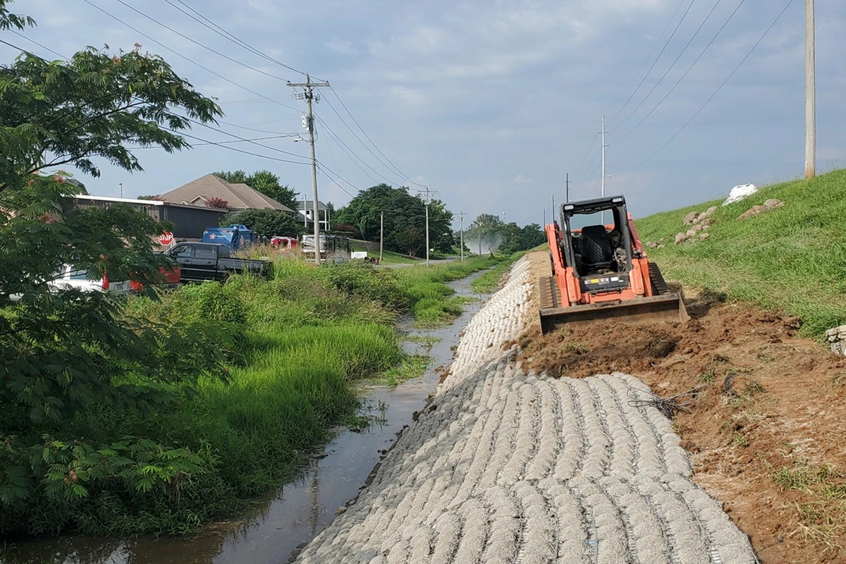 Excavator working on drainage ditch